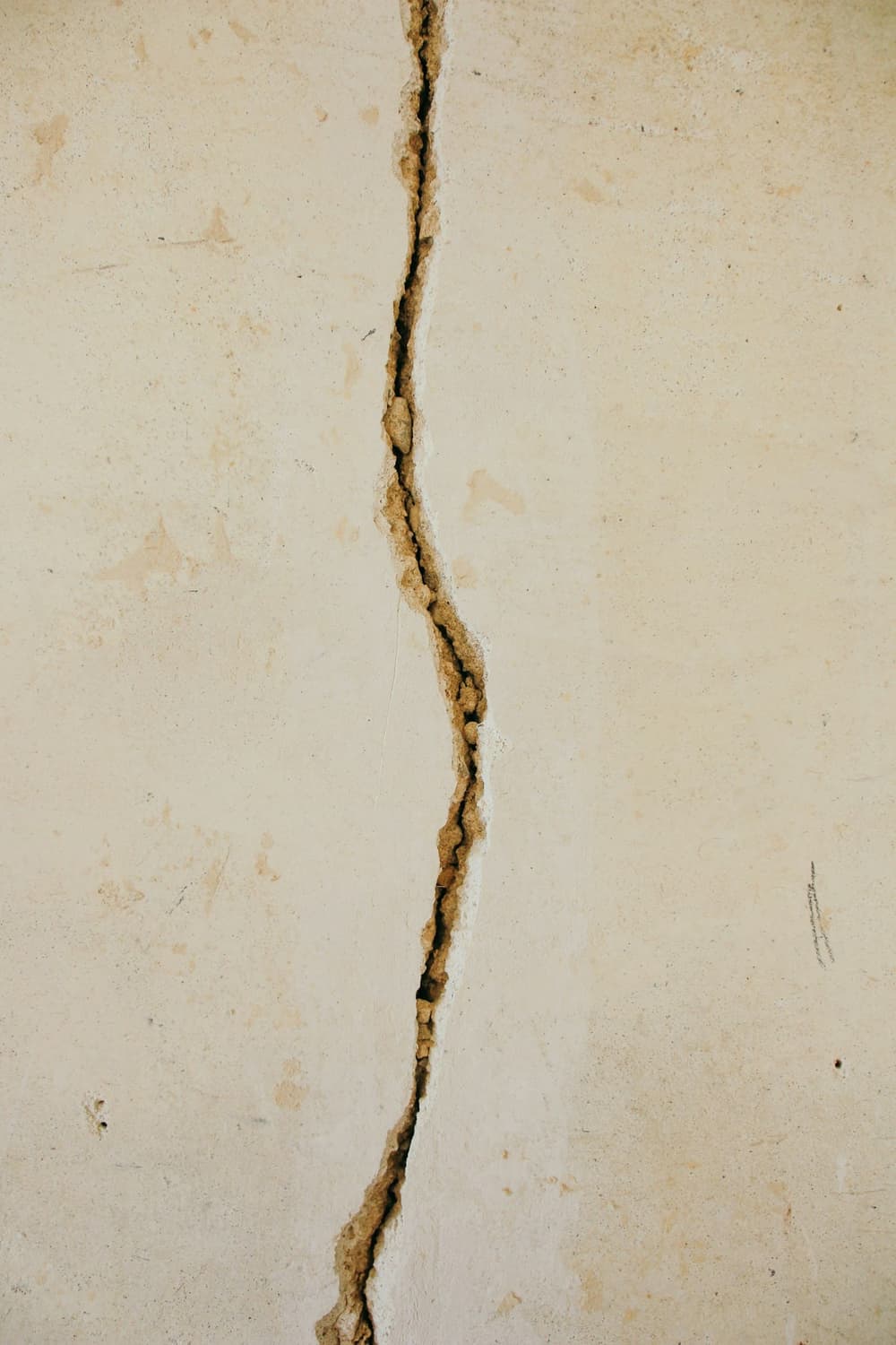 Close-up of a vertical crack running through a concrete wall